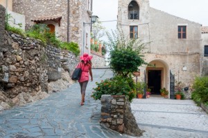 Girl walking through the typical narrow streets of Castelmola, a small tourist village near Taormina, Sicily